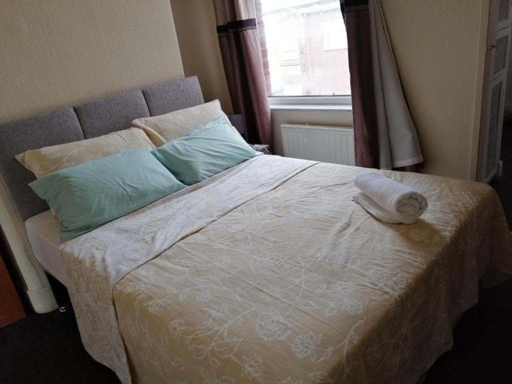 Una cama con una toalla en un dormitorio en Cosy Homes, en Liverpool