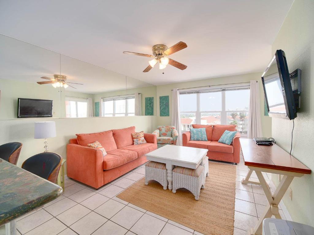 a living room with orange furniture and a flat screen tv at Relaxing Condo, Great Location, 3 Minute Walk To The Beach Condo in South Padre Island