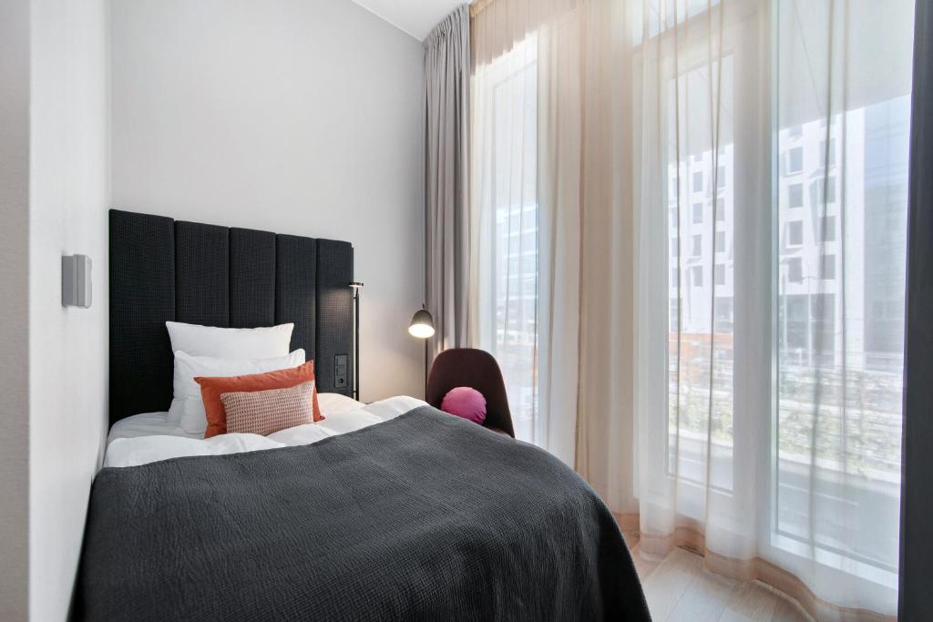 a bedroom with a large bed and a large window at Clarion Hotel Oslo in Oslo