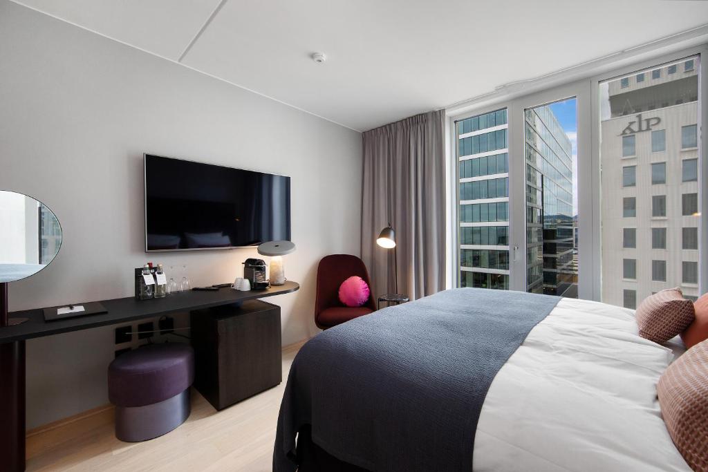 a hotel room with a bed and a flat screen tv at Clarion Hotel Oslo in Oslo