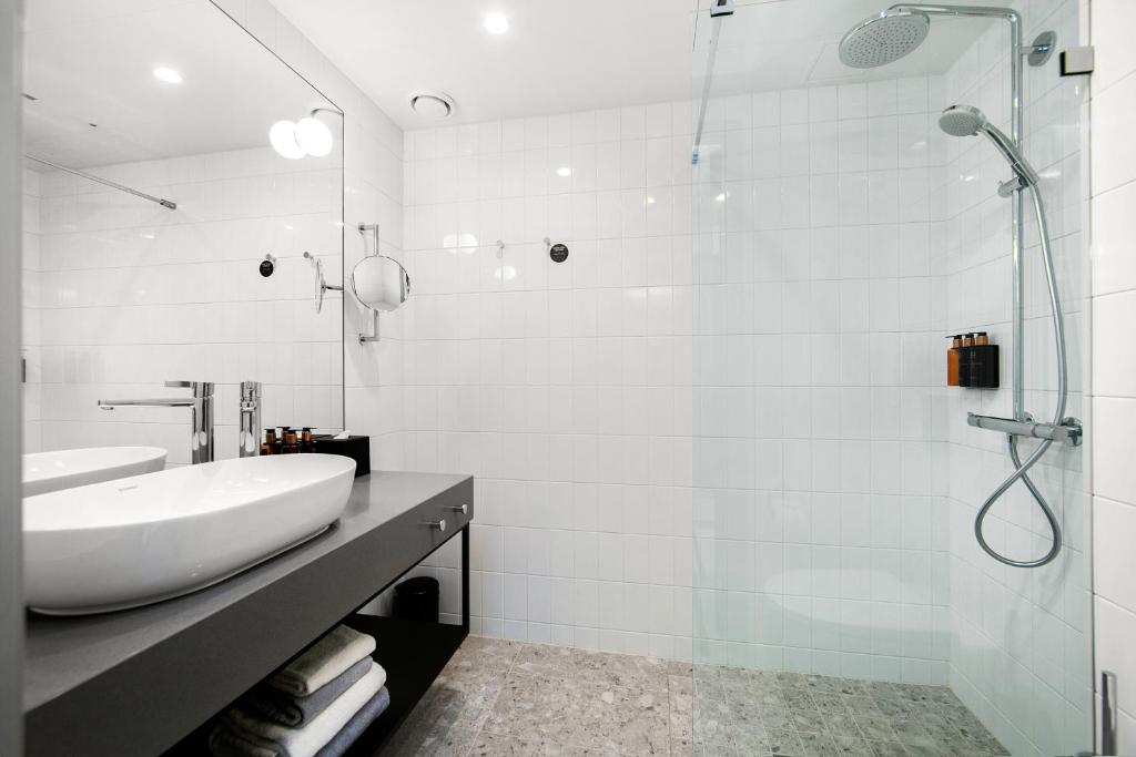 a white bathroom with a sink and a shower at Clarion Hotel Oslo in Oslo