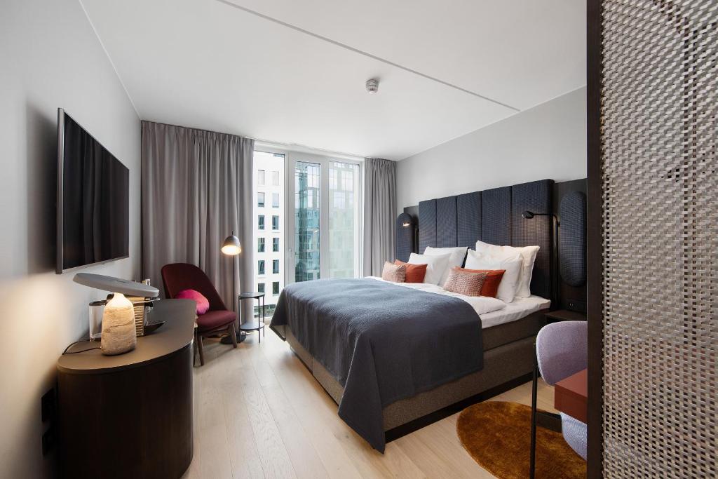 a bedroom with a bed and a desk with a chair at Clarion Hotel Oslo in Oslo