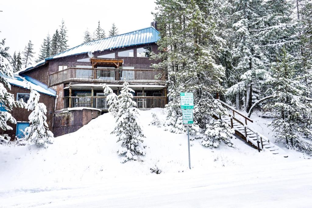 a log cabin in the snow with a sign in front at Flying Stag: Upper Chalet in Government Camp