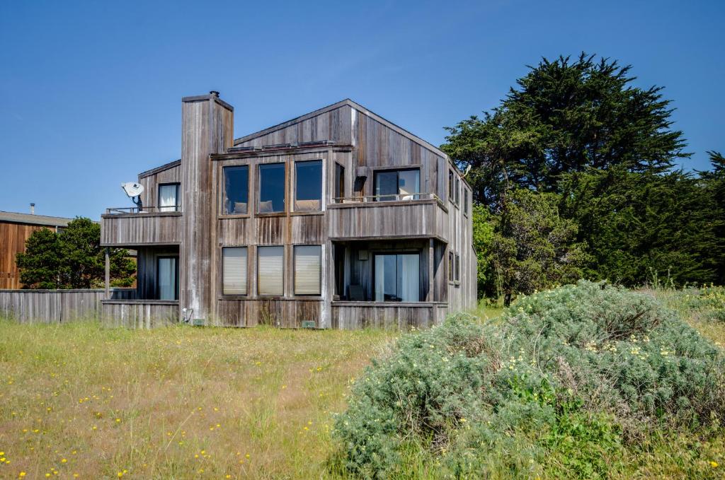 an old wooden house sitting on top of a field at Shell Beach in Sea Ranch