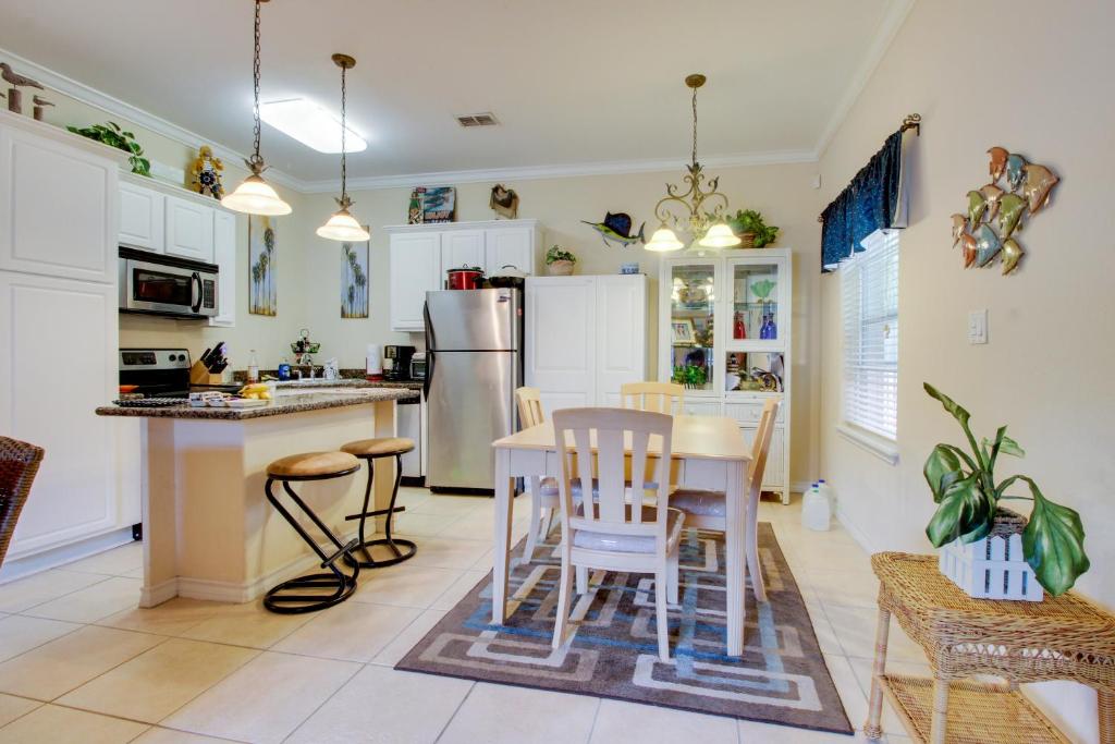a kitchen with white cabinets and a table and chairs at Golden Gate Getaway in South Padre Island