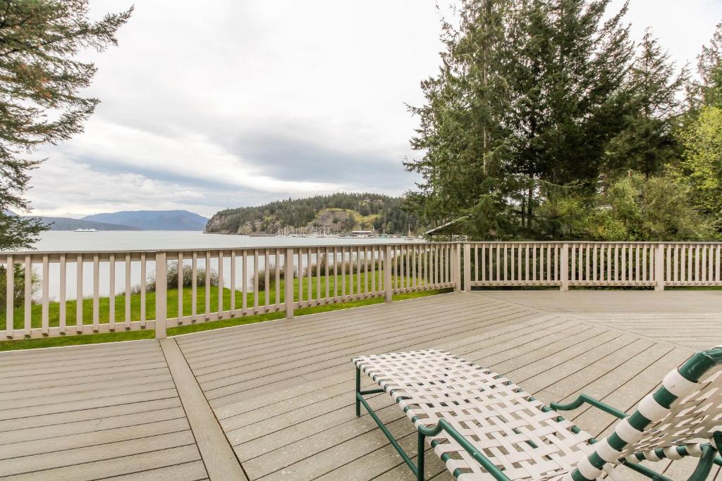 a deck with two chairs and a bench on it at Shoal Bay Luxury Home in Port Stanley