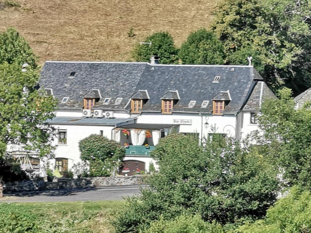 een groot wit huis met een grijs dak bij Hotel bar b'rock in Saint-Martin-sous-Vigouroux