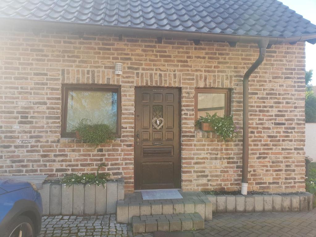 ceglany dom z brązowymi drzwiami w obiekcie Apartment w mieście Euskirchen