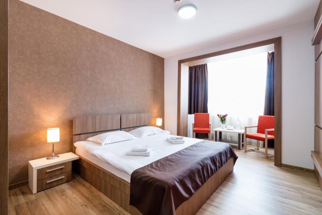 Habitación de hotel con cama, mesa y sillas en HB Brilliant en Braşov