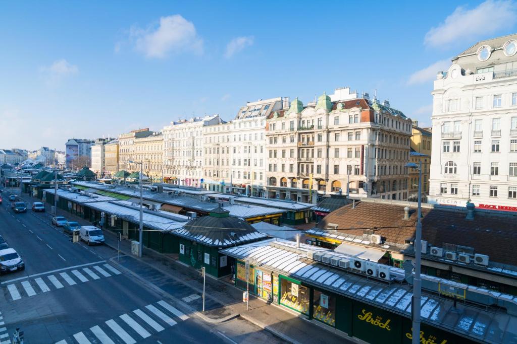 eine Stadtstraße mit Bahnhof und Gebäuden in der Unterkunft Vienna Residence, Naschmarkt - Karlsplatz in Wien