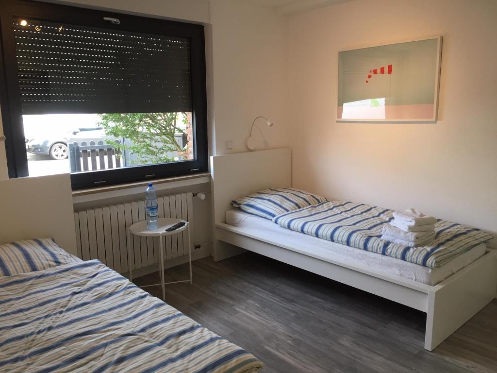 a small bedroom with two beds and a window at Zimmer nahe Messe und Flughafen in Düsseldorf