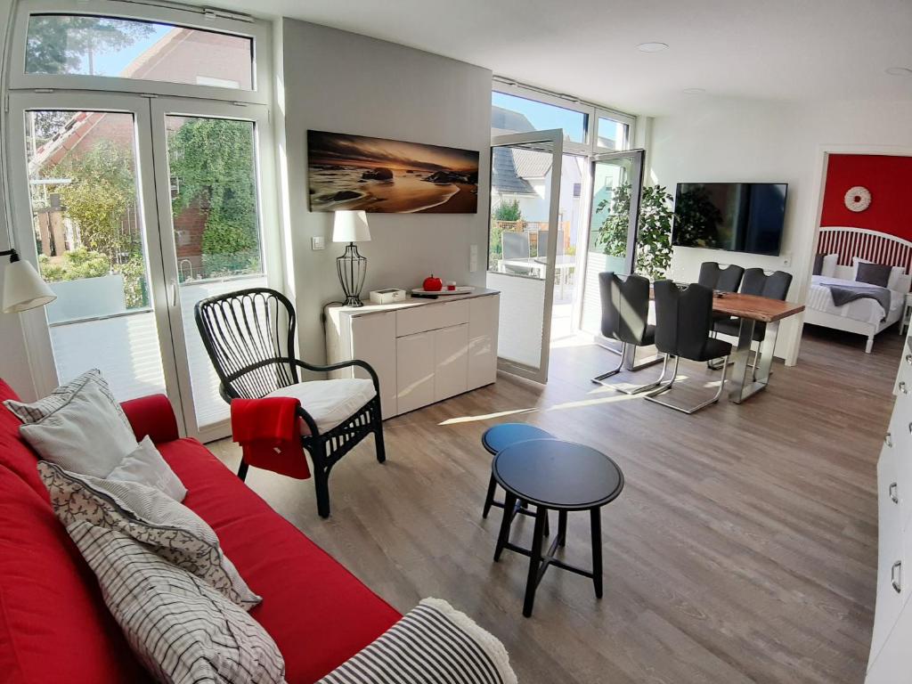 uma sala de estar com um sofá vermelho e uma mesa em Ferienwohnung SteinReich em Glowe