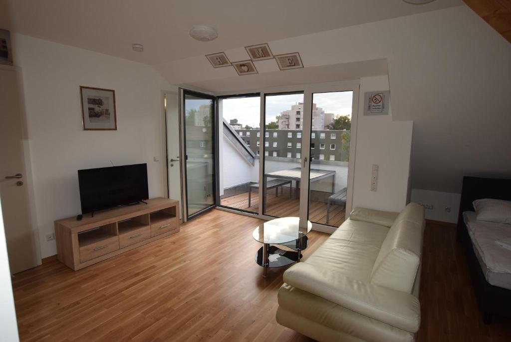 a living room with a couch and a flat screen tv at AB Kornwestheim in Kornwestheim