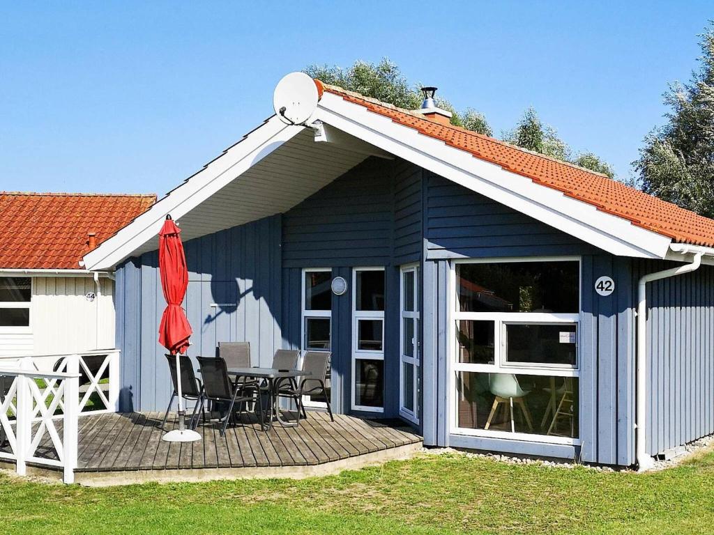 een blauwe schuur met een tafel en stoelen op een terras bij Two-Bedroom Holiday home in Otterndorf 4 in Otterndorf