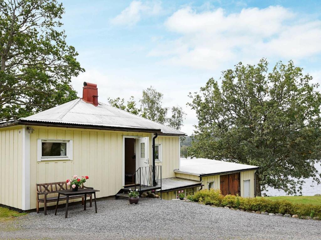 a small white building with a table in front of it at 5 person holiday home in BULLAREN in Stabäckehult