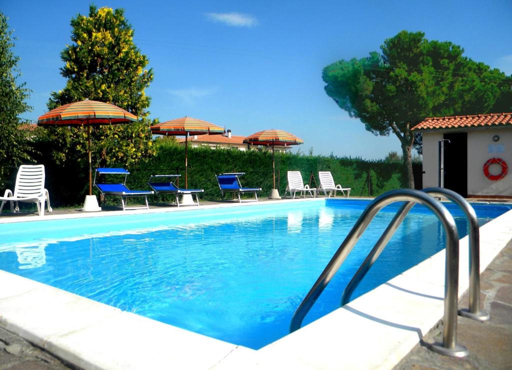 a swimming pool with chairs and umbrellas at Agriturismo La Piana in Castiglione del Lago