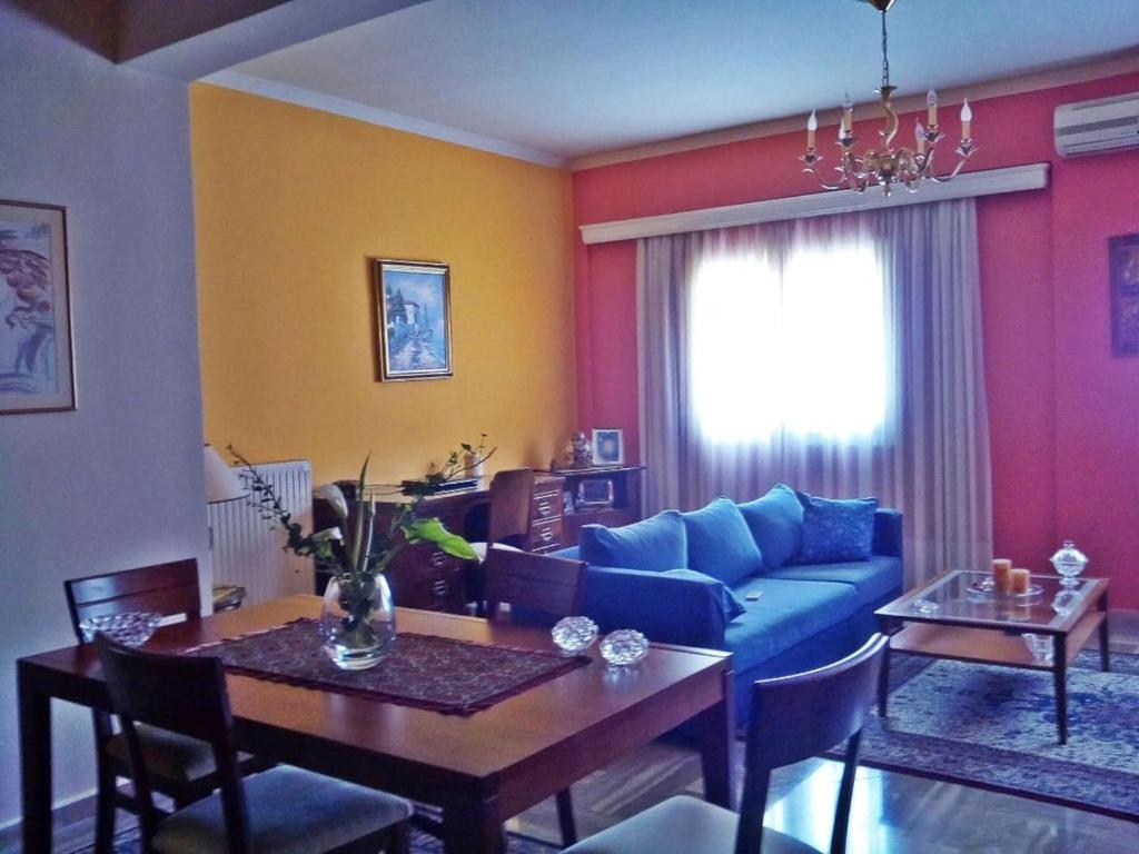 a living room with a blue couch and a table at Detached House 120 sq.m., Kalamia Beach. in Korinthos