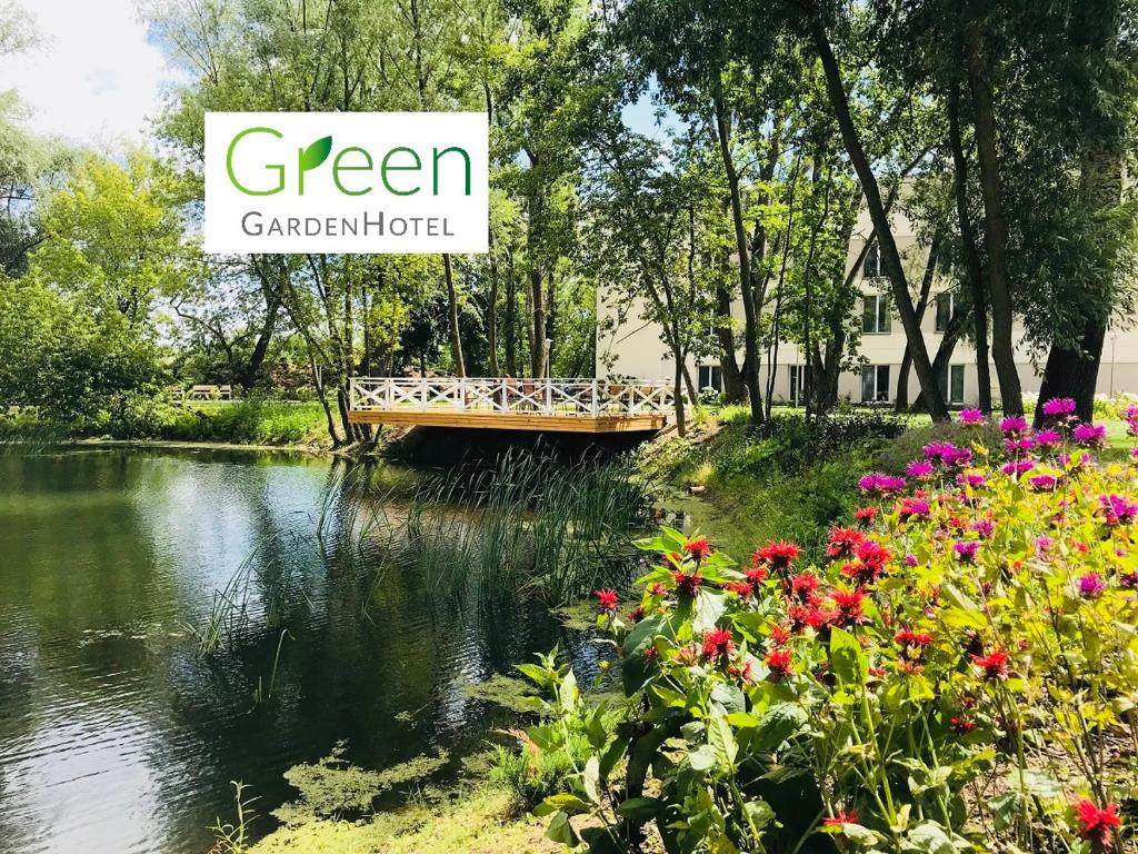 a sign that reads green garden hotel next to a river at Green GardenHotel in Raszyn