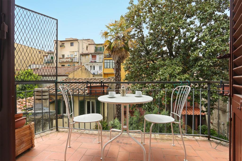a patio with a table and chairs on a balcony at Via della Chiesa Apartments in Florence
