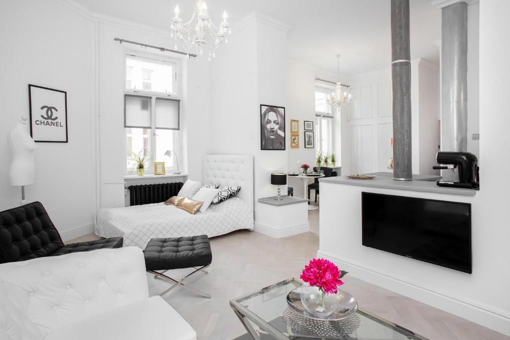 Biały salon z kanapą i telewizorem w obiekcie Apartments Warsaw City Center by Noclegi Renters w Warszawie