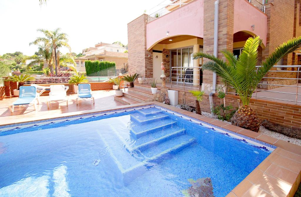 a swimming pool in front of a house at VILLA SOFIA CALELLA in Calella