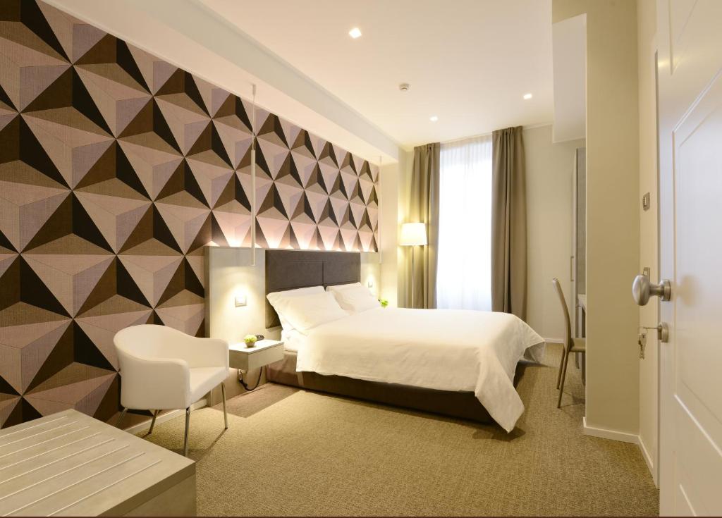 a bedroom with a bed and a geometric wall at Hotel Repubblica 55 in Biella