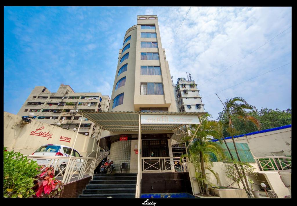 a tall building with stairs in front of a building at Lucky Hotel Goregaon in Mumbai