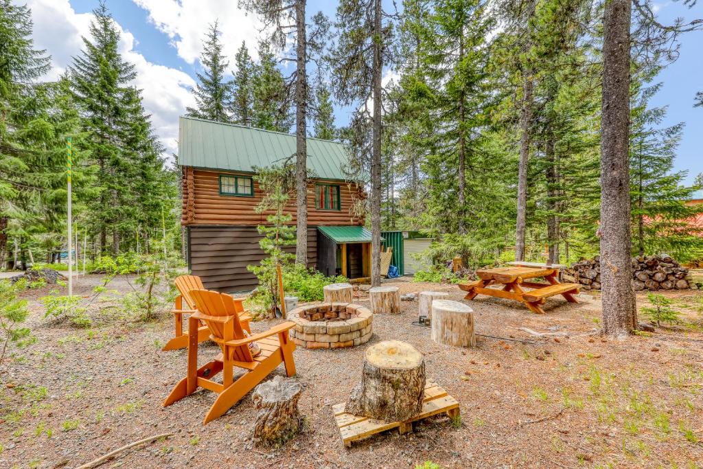a cabin in the woods with a fire pit and picnic tables at Wy'east Nest in Government Camp