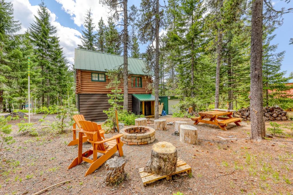 uma cabana na floresta com uma fogueira e mesas de piquenique em Wy'east Nest em Government Camp