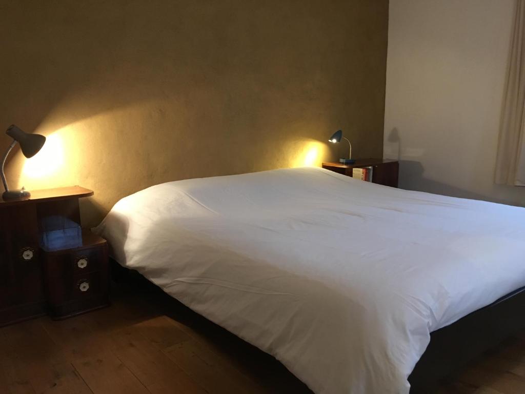 敘里斯的住宿－Le Rockormoran，卧室配有一张白色大床和2个床头柜