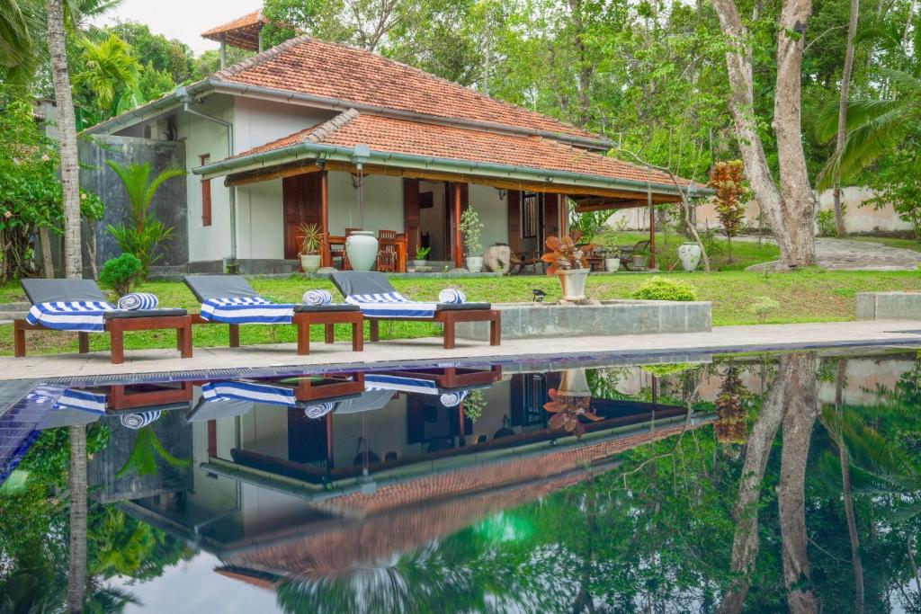 a villa with a pool in front of a house at Villa Godahena in Ambalangoda