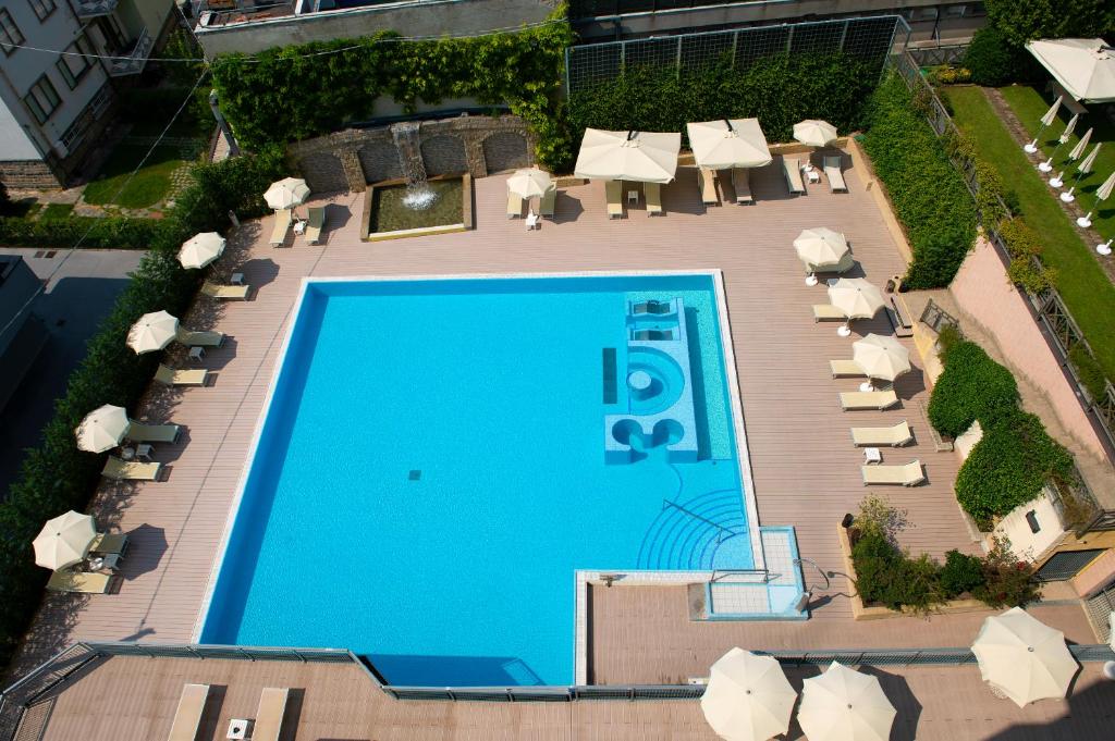 an overhead view of a swimming pool with chairs and umbrellas at Hotel Terme Paradiso in Abano Terme