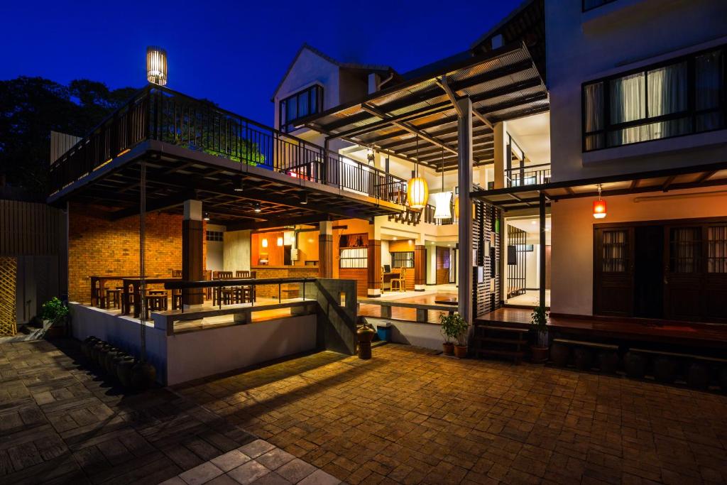 a house with a balcony and a patio at night at Baan Ing Ping in Chiang Mai