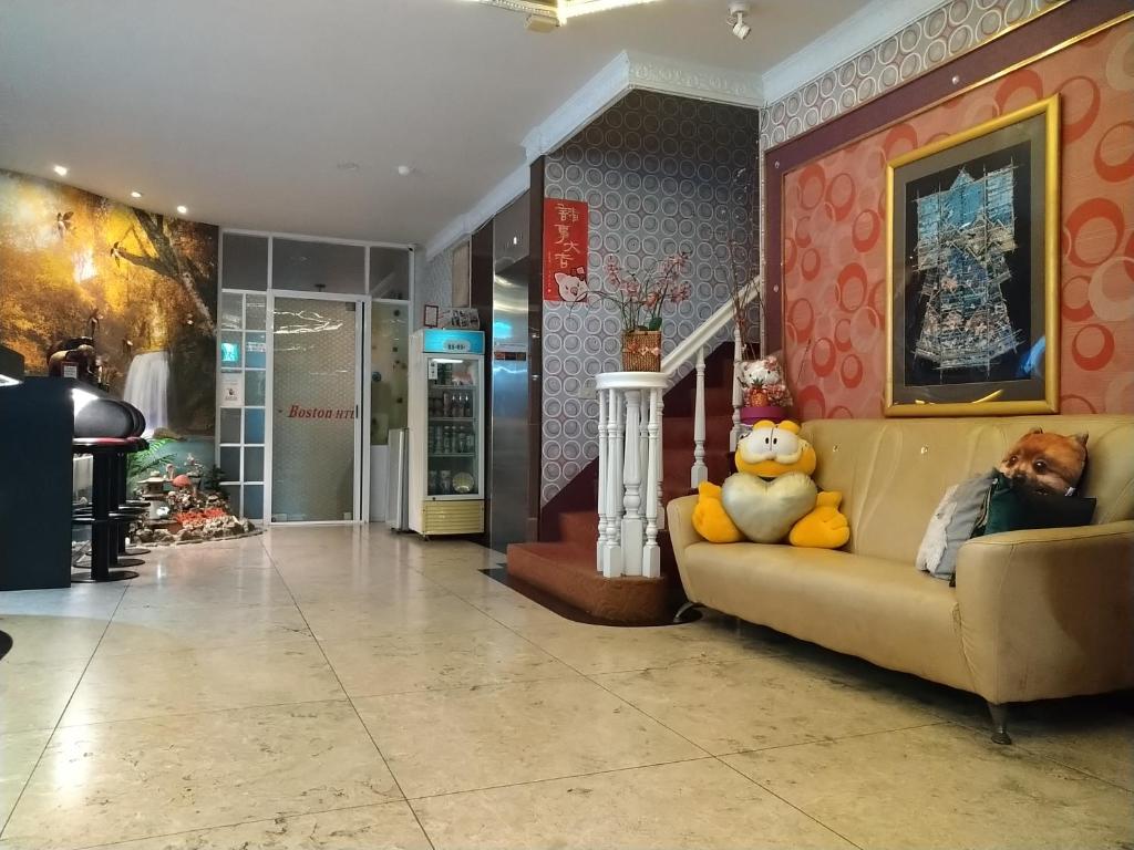 a teddy bear sitting on a couch in a lobby at Boston Hotel in Chiayi City