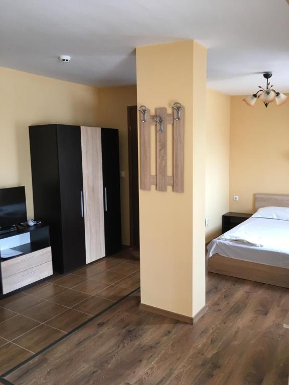 a bedroom with a bed and a tv in a room at Horizont Apartments in Sunny Beach