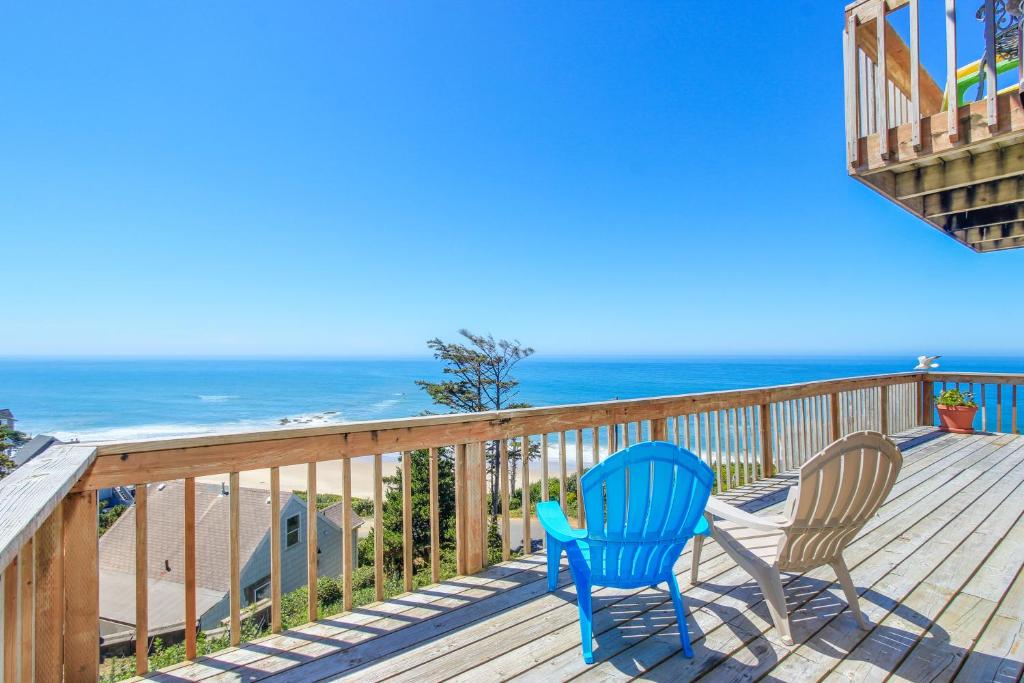 a deck with two chairs and the beach at Ocean Escape in Lincoln City