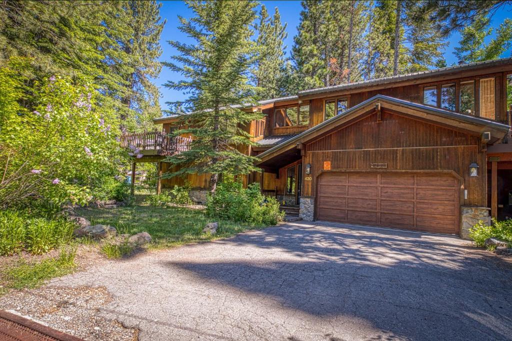 a large house with a garage in the woods at Park Avenue Tahoe Lodge in Homewood