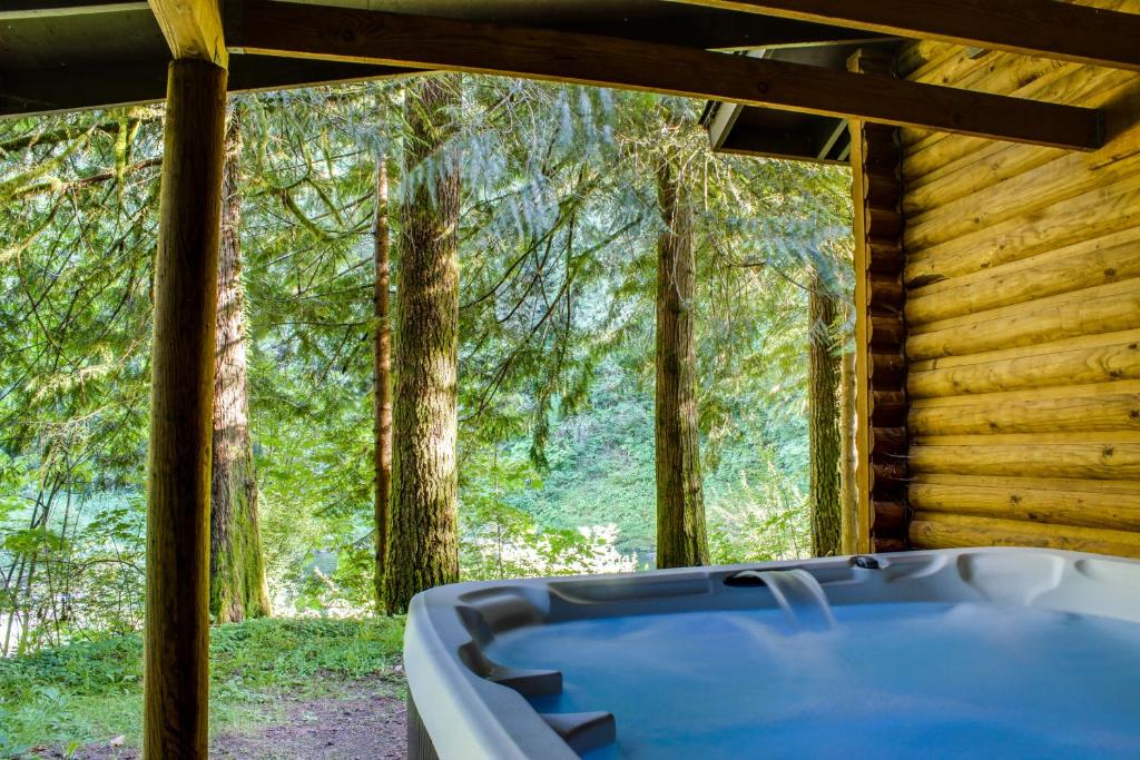 une baignoire dans une cabane en rondins dans les bois dans l'établissement River Bend Lodge, à Washougal