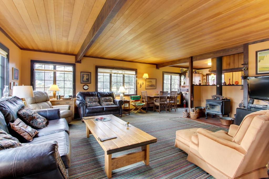 a living room with leather furniture and a wooden ceiling at Historic Haystack Cabin in Cannon Beach