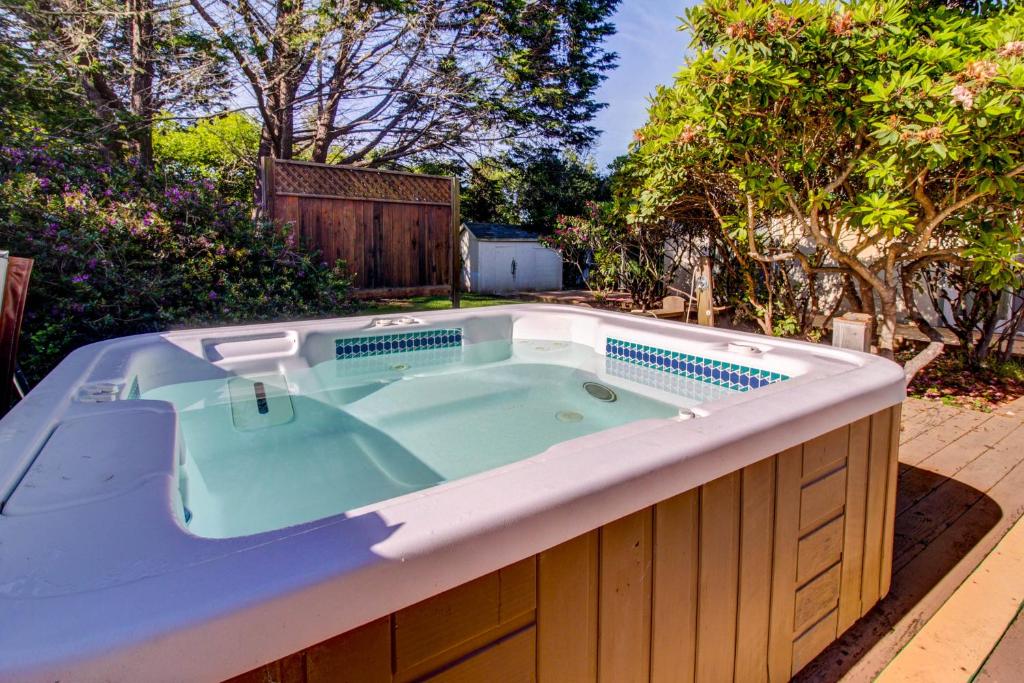 a jacuzzi tub in a yard with trees at Mendocino Dunes - Distant Shores in Fort Bragg