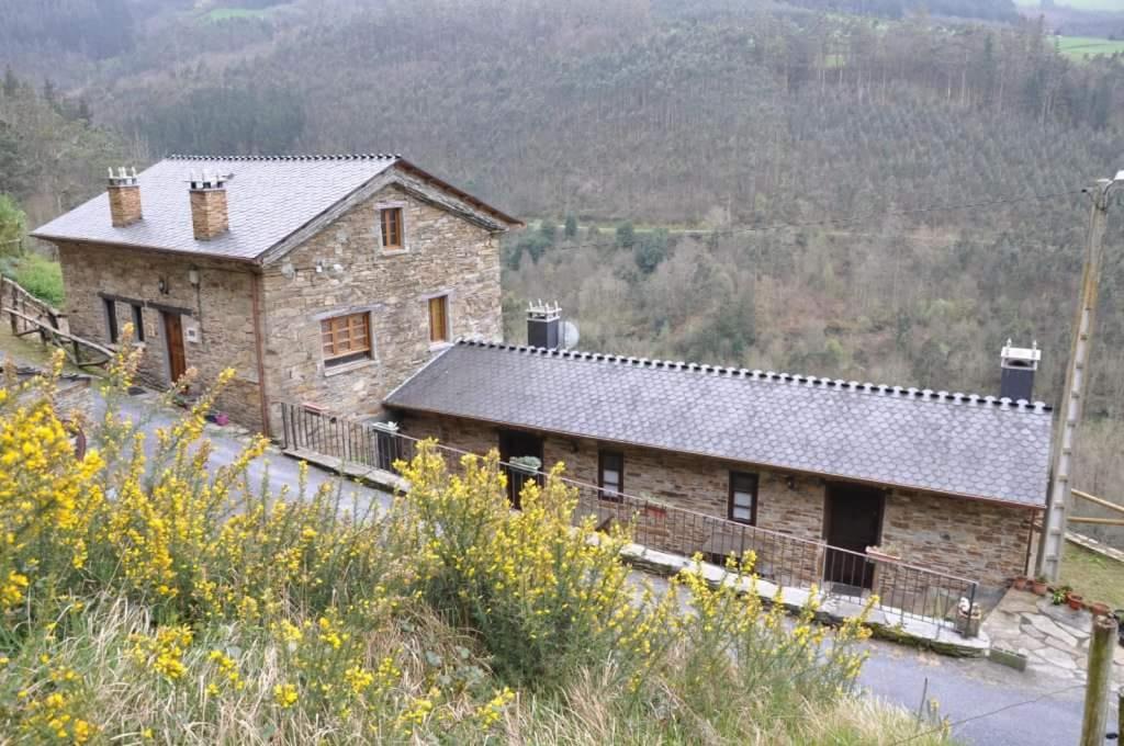 una casa de piedra al lado de una colina en Apartamento El Acebo, en Prado