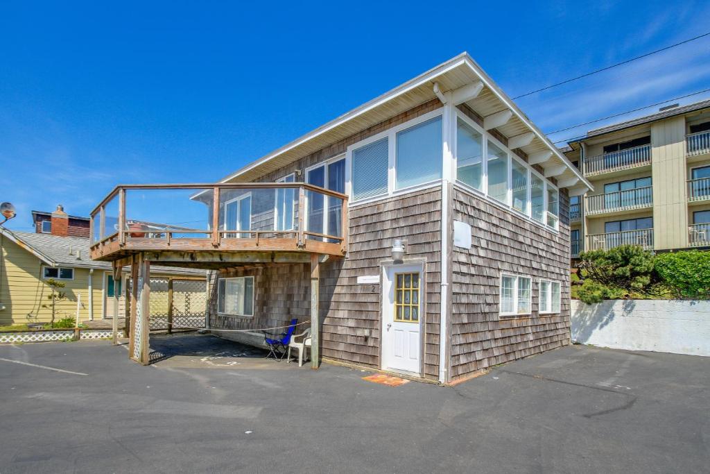 a house with a deck on the side of it at Flounder's Crib Condo in Lincoln City
