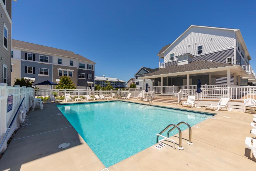 a large swimming pool with chairs and a building at Broad Marsh Beach House in Ocean City