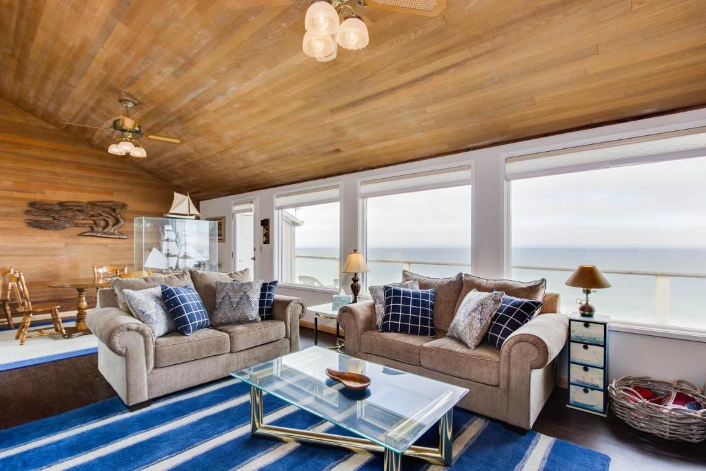 a living room with two couches and a table at At The Seaside in Lincoln Beach