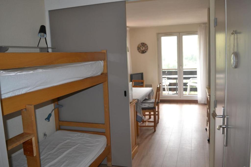 a room with two bunk beds and a room with a balcony at Appartement pied des pistes 4 à 6 pers - Les Deux-Alpes in Les Deux Alpes