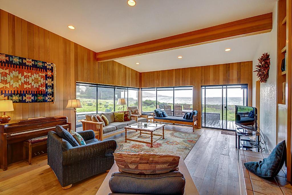 a living room with wood paneling and a piano at Aloha House in Sea Ranch