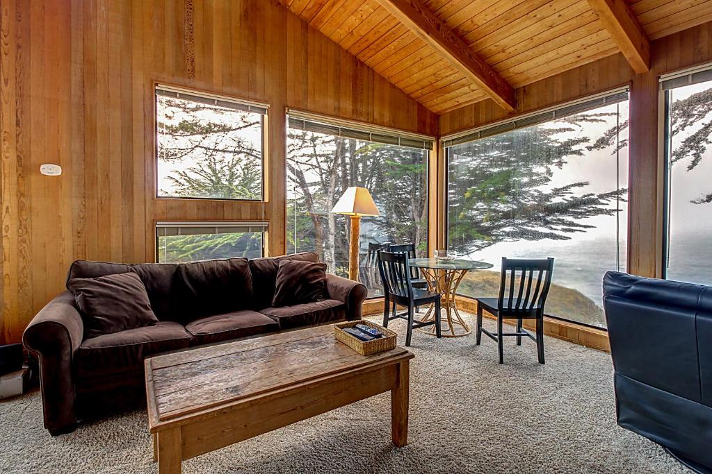 ein Wohnzimmer mit einem Sofa und einem Tisch mit Stühlen in der Unterkunft Stoney House in Sea Ranch