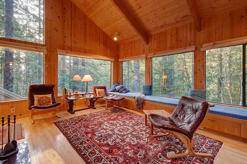 a living room with a couch and chairs and windows at Longwell House in Sea Ranch