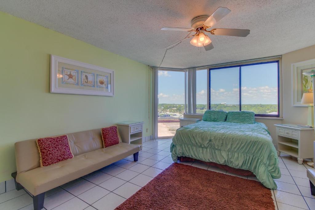 um quarto com uma cama, um sofá e uma janela em The Top of the Gulf #818 em Panama City Beach