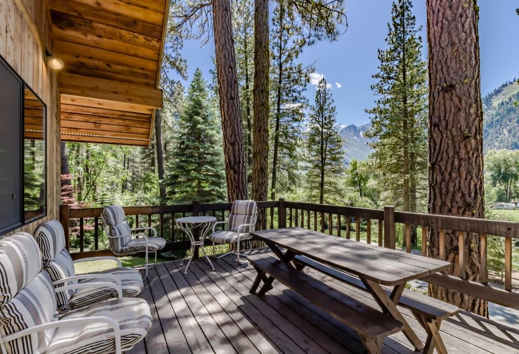 una terraza de madera con mesa y sillas de madera en Buddington Haus, en Leavenworth